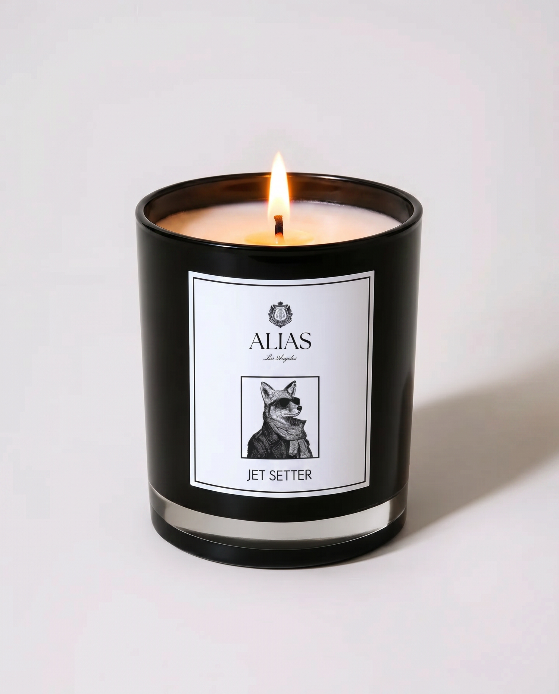 Alias Los Angeles The Jetsetter candle – glossy black jar filled with a luxurious blend of black tea, cedarwood, and Sicilian bergamot; a sophisticated coconut apricot wax candle designed for world travelers, luxury interiors, and elevated self-care rituals.