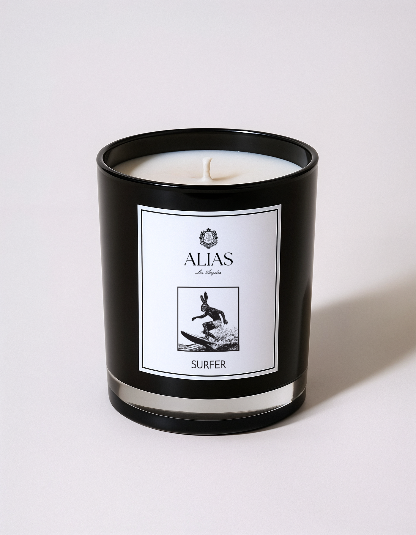 The Surfer luxury candle by Alias Los Angeles – glossy black jar with a fresh coastal fragrance of sea spray, koa wood, and ylang ylang; a soy wax candle inspired by California beach lifestyle, perfect for summer home décor, beach house ambiance, and thoughtful gifting.