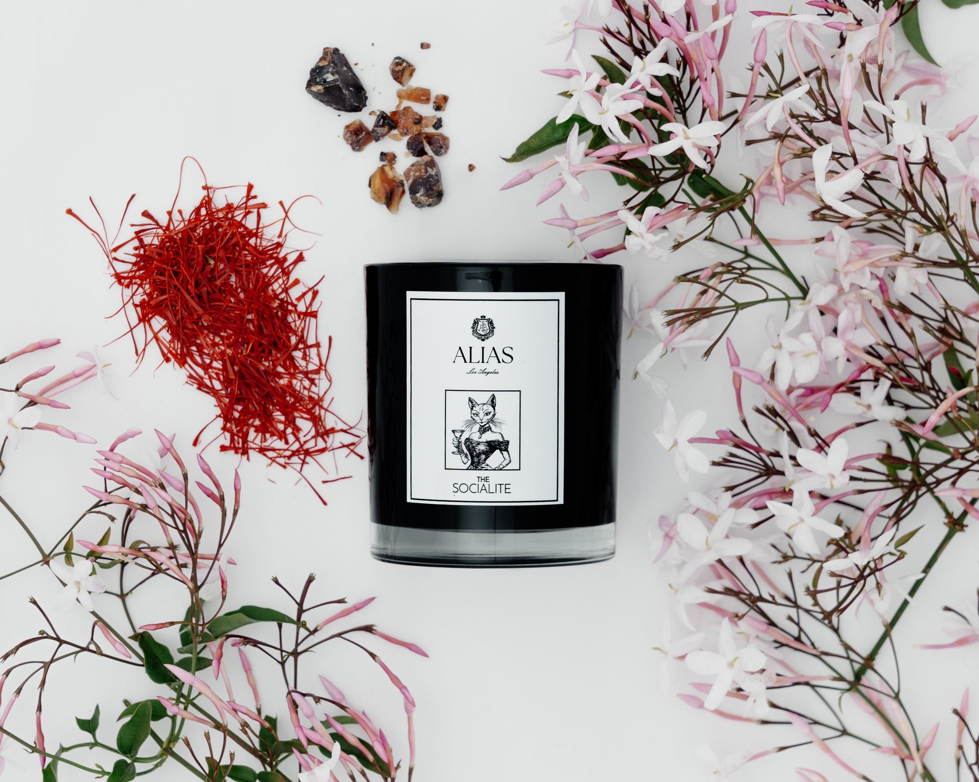 Light the Socialite candle — a signature scent from Alias Los Angeles featuring floral jasmine, rich amber, and spicy saffron for an unforgettable ambiance.
