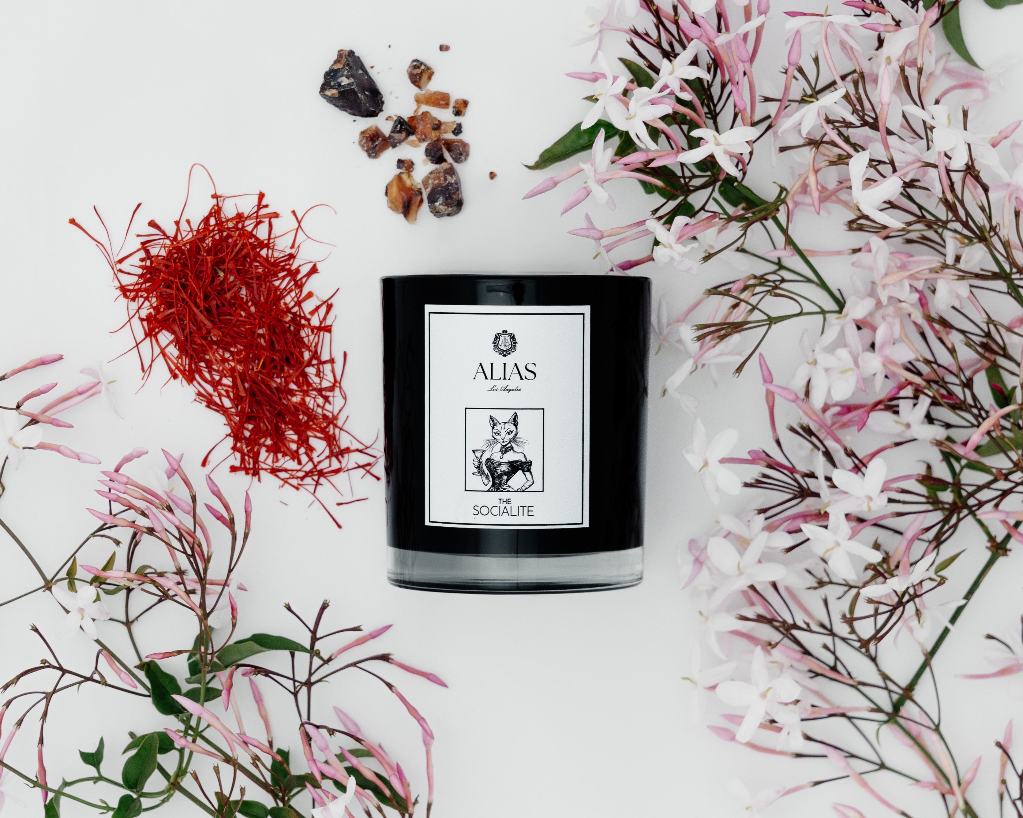 Light the Socialite candle — a signature scent from Alias Los Angeles featuring floral jasmine, rich amber, and spicy saffron for an unforgettable ambiance.