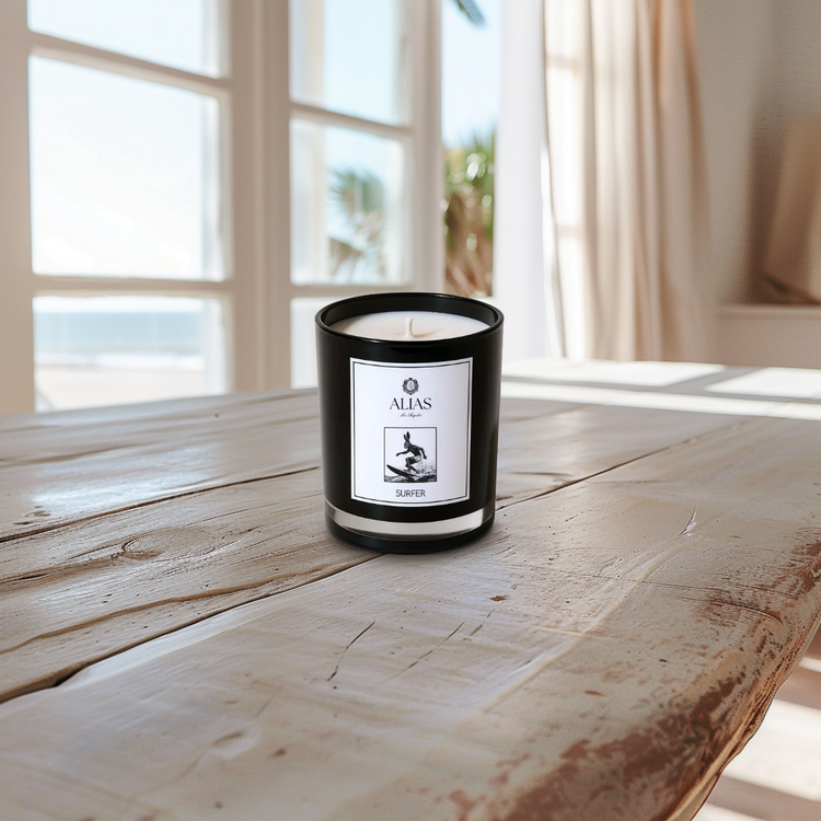 Candle with a label on a wooden table by a window