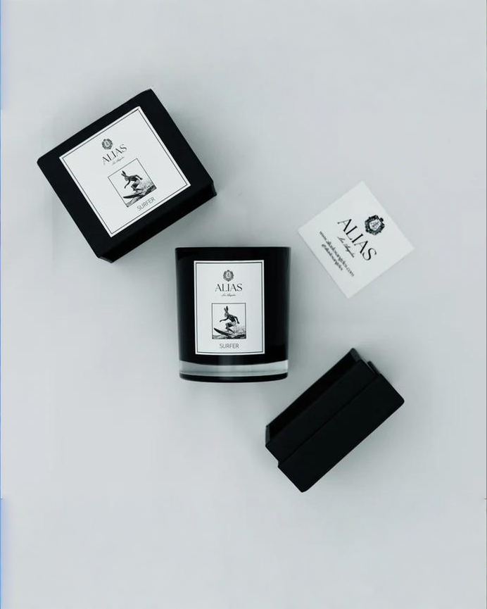 The Surfer candle by Alias Los Angeles showcasing a coastal inspired scent blend of sea spray ylang ylang birchwood and koa wood in elegant packaging
